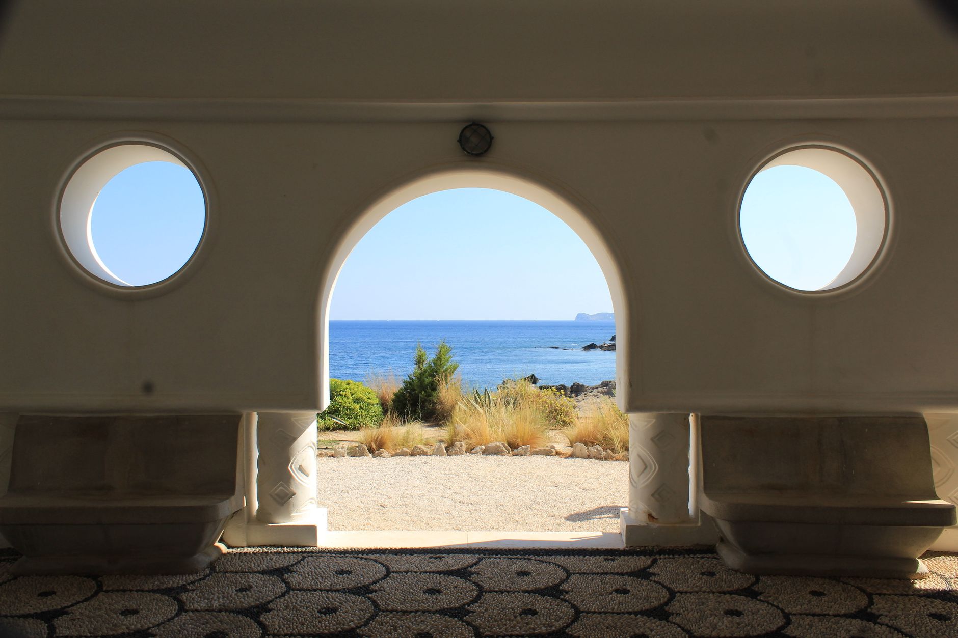 Architectural interior opening into coastal landscape